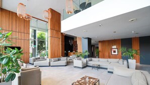 A spacious lobby with multiple seating areas, a reception desk, and large windows offering views of greenery. - Longue Vie Hôtels (Marrakech)