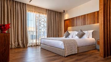 Un dormitorio moderno con una cama grande, paneles de madera en las paredes y vistas al exterior a través de cortinas traslúcidas.