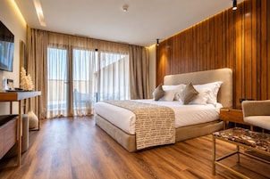 Una habitación de hotel moderna con una cama grande, un escritorio y un espacio de descanso.