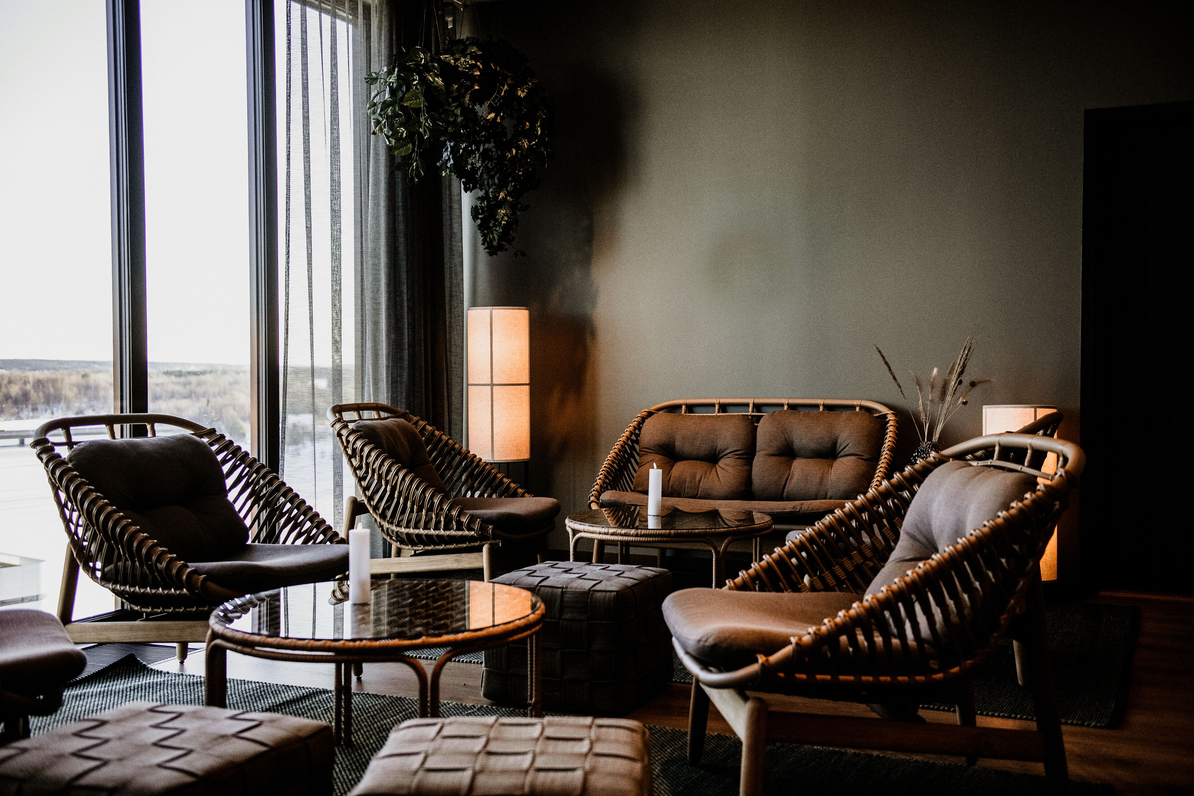 Un rincón tranquilo con muebles de mimbre, un sofá acolchado y una mesita.