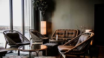 Un rincón tranquilo con muebles de mimbre, un sofá acolchado y una mesita.