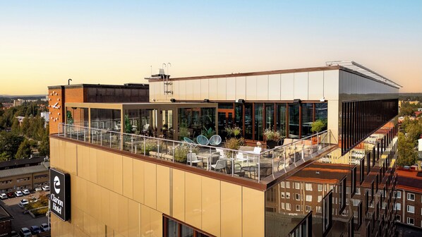 A hotel with a rooftop terrace featuring outdoor seating and a view of the cityscape. - Clarion Hotel Umea (Umea)