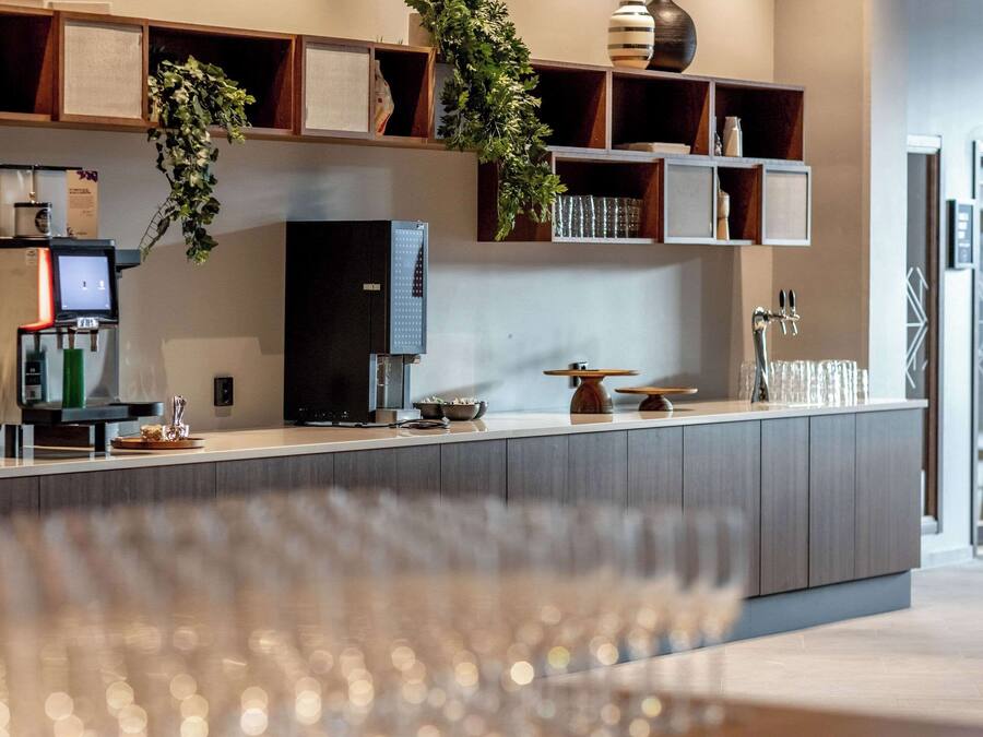 Una cocina moderna con cafetera integrada, un refrigerador grande y una encimera de madera.