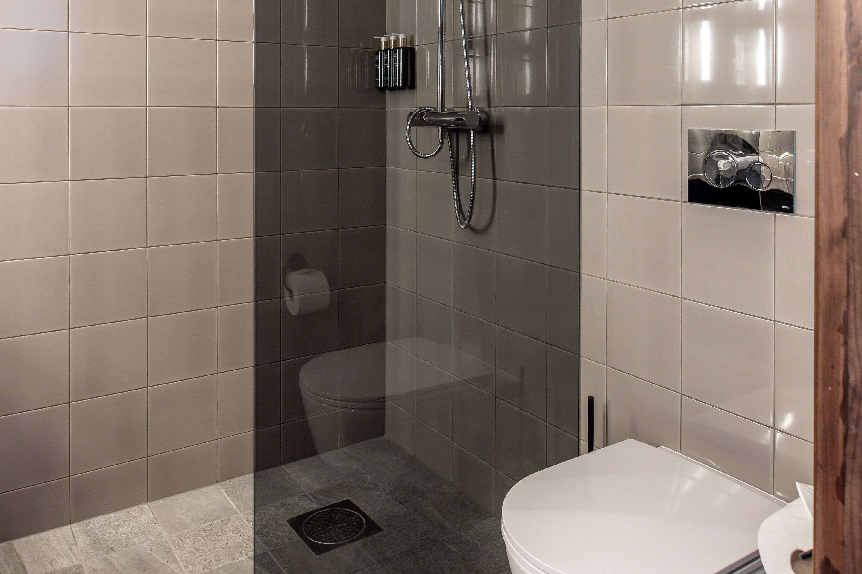 Un baño moderno con ducha de vidrio, inodoro y lavamanos.