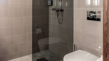 Un baño moderno con ducha de vidrio, inodoro y lavamanos.