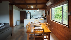 A modern kitchen with wooden cabinets, a central island, and pendant lighting. - ALPINE ALLURE - ALL SEASONS WONDER (Tawonga South)