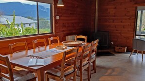 A wooden dining table with chairs, a woven basket, and a placemat. - ALPINE ALLURE - ALL SEASONS WONDER (Tawonga South)