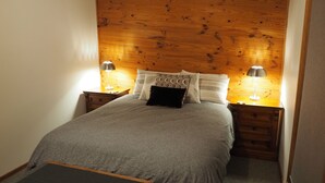 A neatly made bed with a grey blanket, two bedside lamps, and a wooden headboard. - ALPINE ALLURE - ALL SEASONS WONDER (Tawonga South)