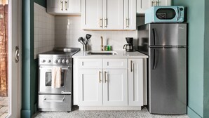 A compact kitchen with white cabinets, a stainless steel stove, and a refrigerator. - 108 · ☀Pool✔ Kitchen✔ Beach✔ Self Checkin✔ Free Parking✔ (Clearwater)