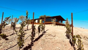 A modern house with a wooden deck, surrounded by a vineyard. - Dwell Magazine Featured Vineyard Home (Paso Robles)
