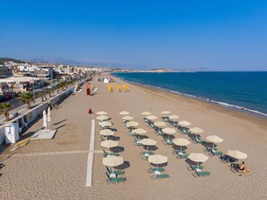 En la playa, playa de arena blanca, camastros y sombrillas