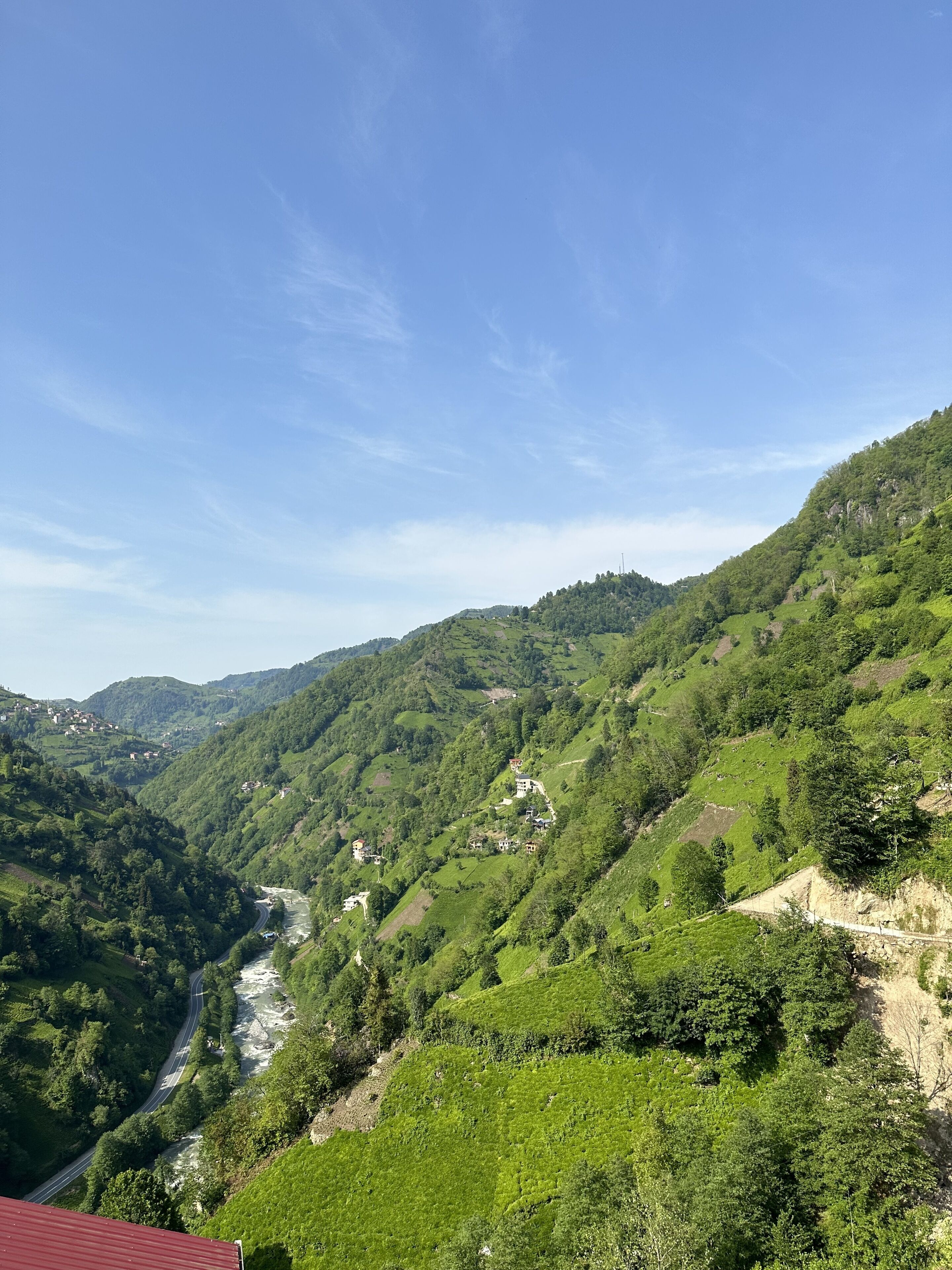 Un paisaje montañoso con un camino sinuoso y un río.