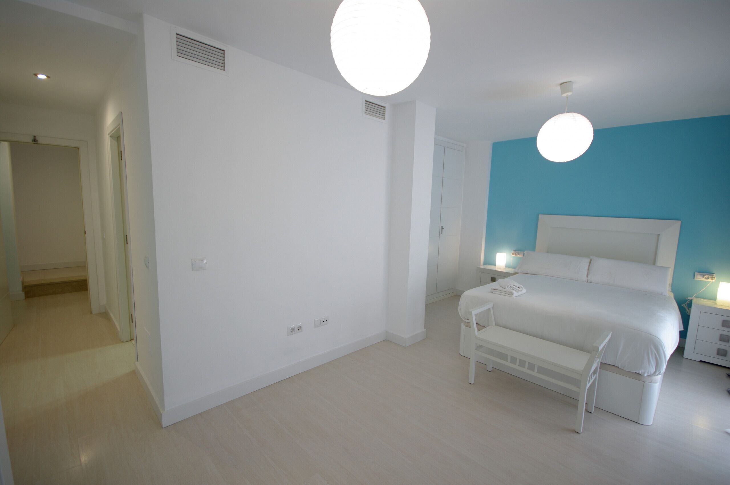 A bedroom with a bed, bedside tables, and a bench.
