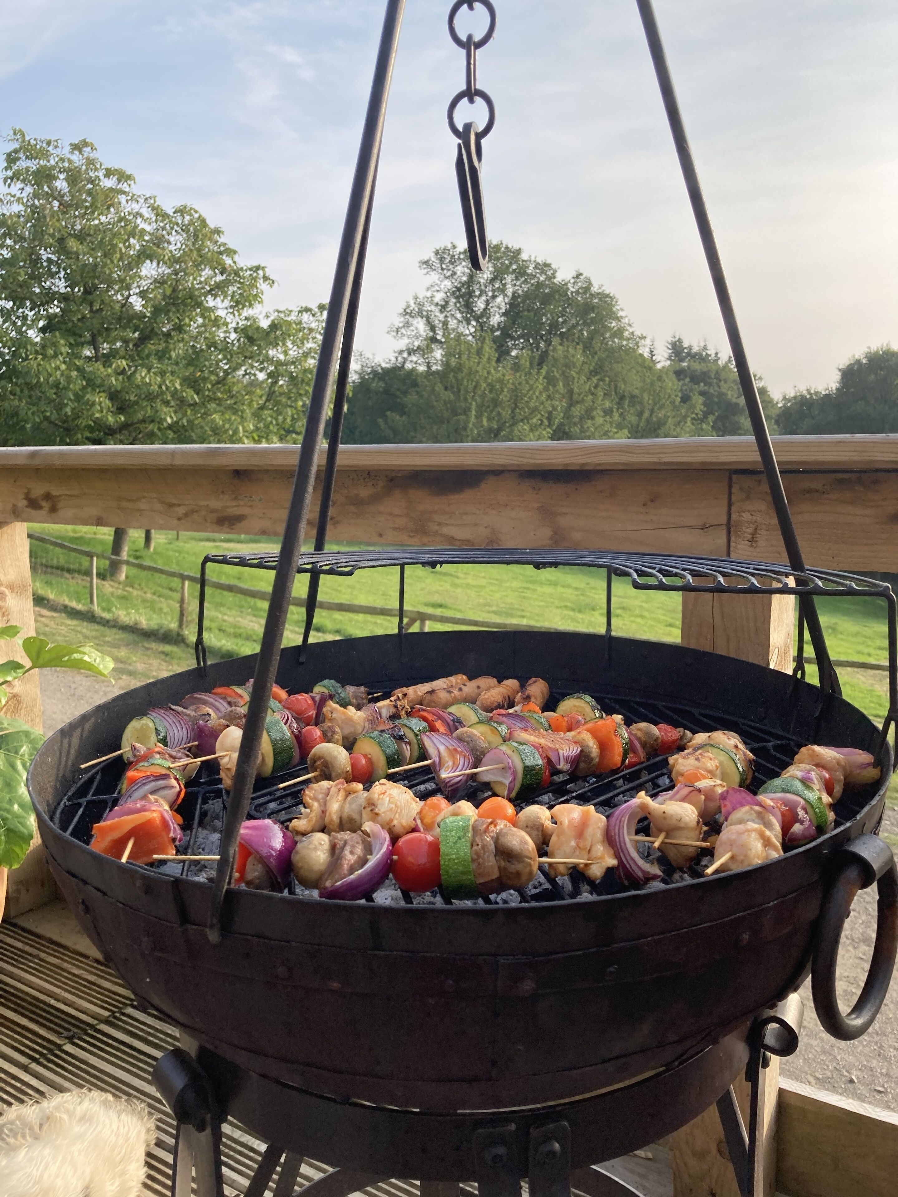 A barbecue grill with skewers of vegetables and meat.