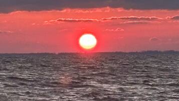 A sunset over the ocean with waves.