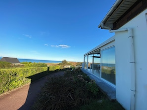 Una casa moderna amb una porta de vidre i vista al mar.