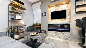 Apartamento luxo | Área de estar | TV de tela plana 58 cm com canais a cabo, TV, smart speakers