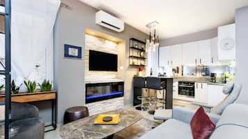 Deluxe Apartment | Living area | 58-cm flat-screen TV with cable channels, TV, smart speakers