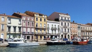Une promenade en bord de mer, avec des bâtiments aux couleurs vives et des bateaux amarrés le long de la rive.