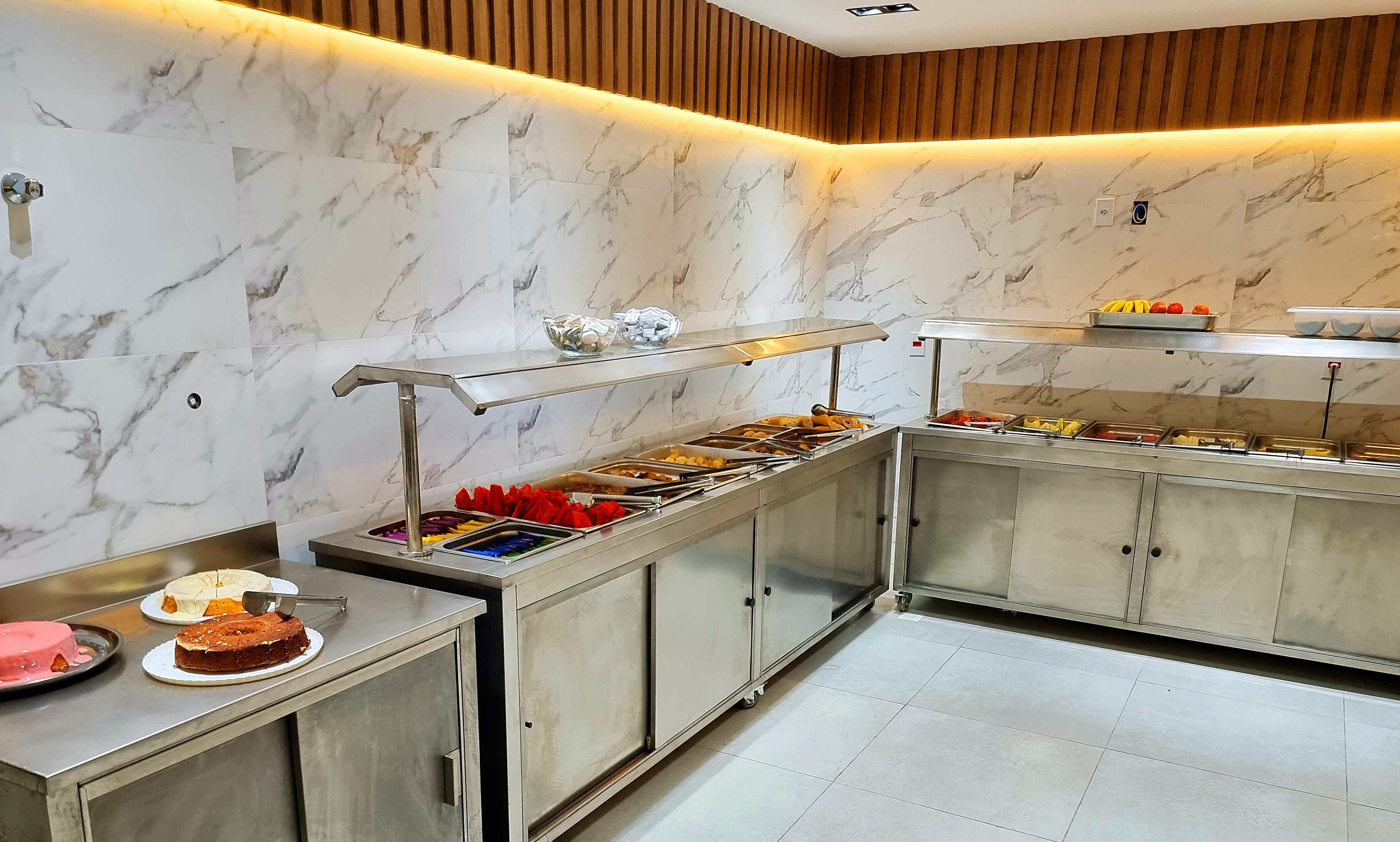 A buffet area with marble walls and a variety of food options.