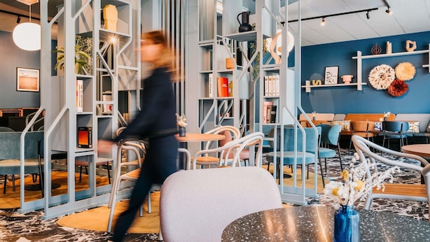 A modern interior with a central seating area, a bookshelf, and a decorative wall. - Mercure Brest Centre Port (Brest)