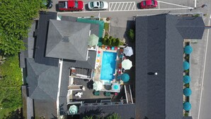 An aerial view of a hotel with a swimming pool, outdoor seating, and a parking area. - Beach Motel & Suites (Old Orchard Beach)