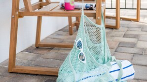 A wooden chair with a bottle and a bag on the ground. - 114 · Pool Beach Self Checkin Free Parking (Clearwater)