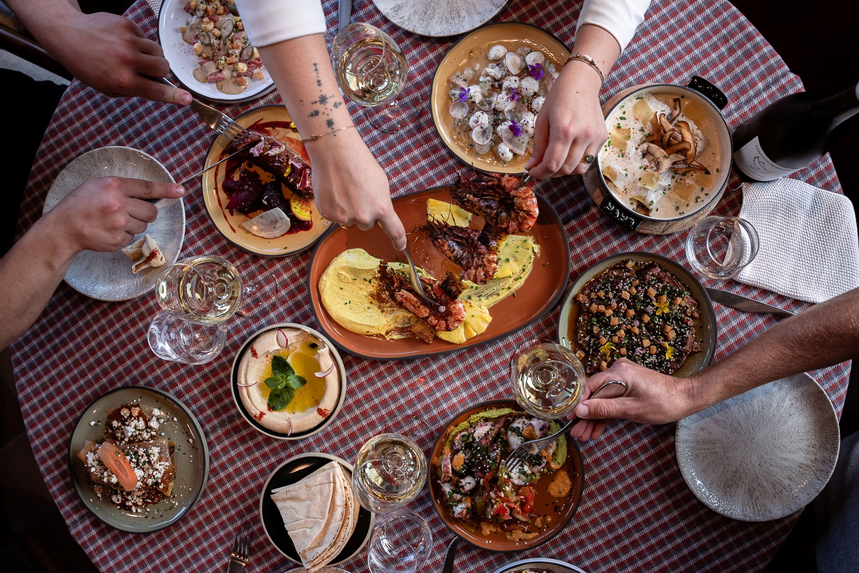 A group of people dining at a table with various dishes and drinks.