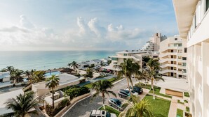 A resort with a pool, palm trees, and a view of the ocean. - Brisas Beachfront Penthouses (Cancun)
