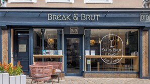 A storefront with the sign "BREAK & BRUT" and a window display for "EXTRA BRUT CAVE & BAR À VINS". - Break & Brut (Nogent-le-Roi)