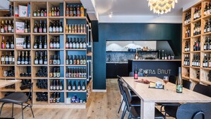 A modern bar with wooden shelves stocked with various bottles and glasses. - Break & Brut (Nogent-le-Roi)