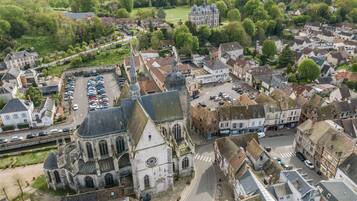An aerial view of a historic town with a prominent church, narrow streets, and a mix of residential and commercial buildings.