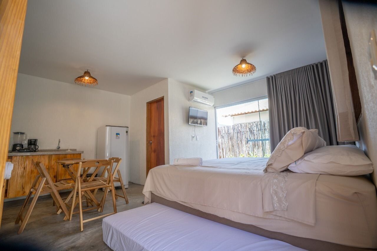 Une chambre à coucher comprenant un lit, un bureau avec une chaise, un téléviseur et un appareil de climatisation.