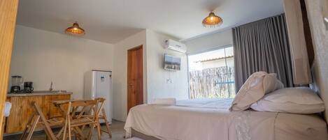 Une chambre à coucher comprenant un lit, un bureau avec une chaise, un téléviseur et un appareil de climatisation.