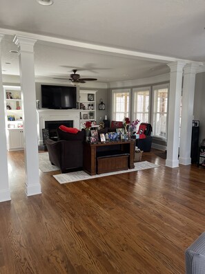 Relax in this inviting living room with a large flat-screen TV, fireplace, and comfortable sofa.