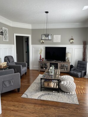 Relax in this stylish living room with a large flat-screen TV, two sofas, and a coffee table.
