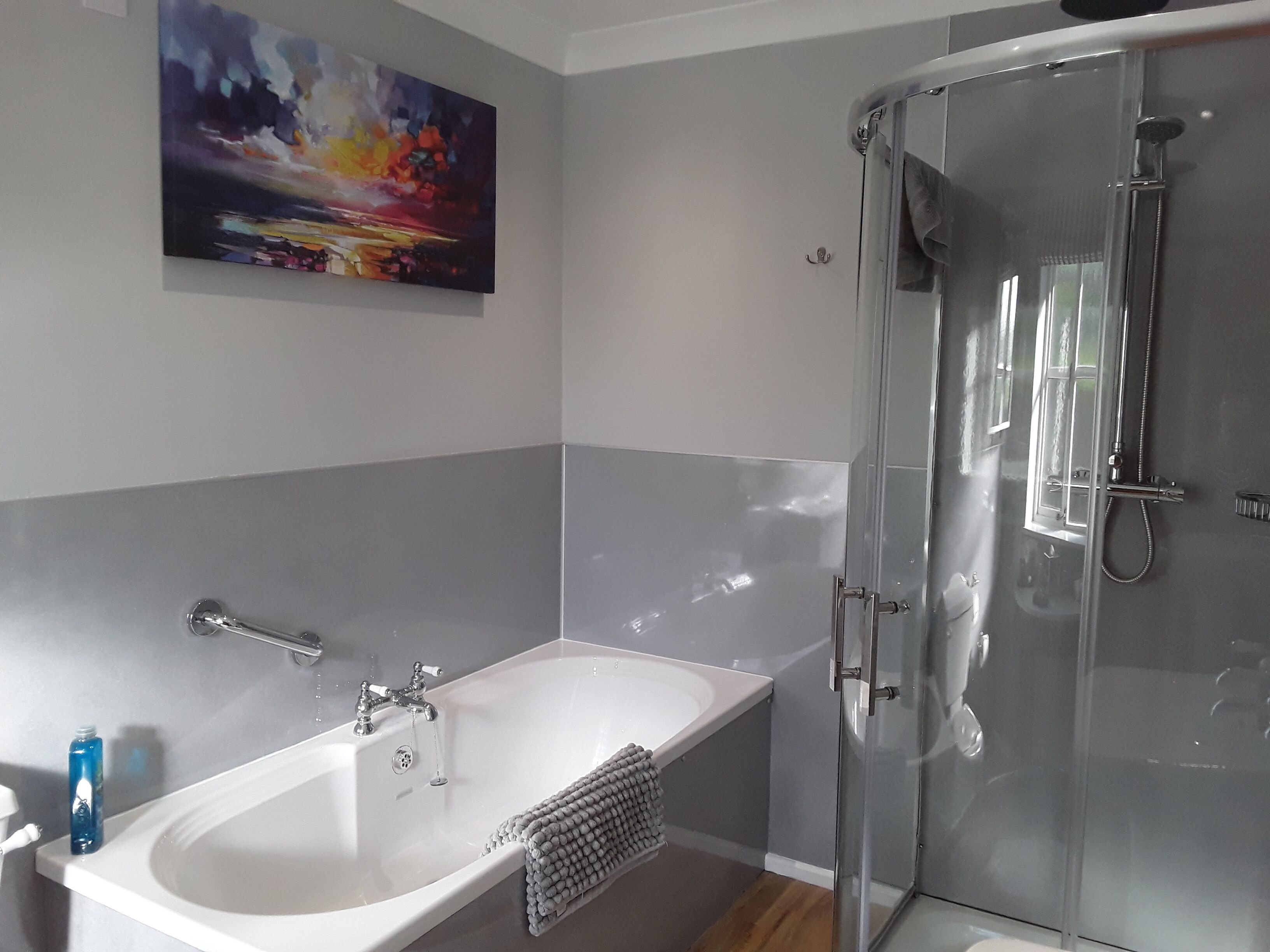 Un baño moderno con bañera, ducha y cabina de ducha con mampara de vidrio.