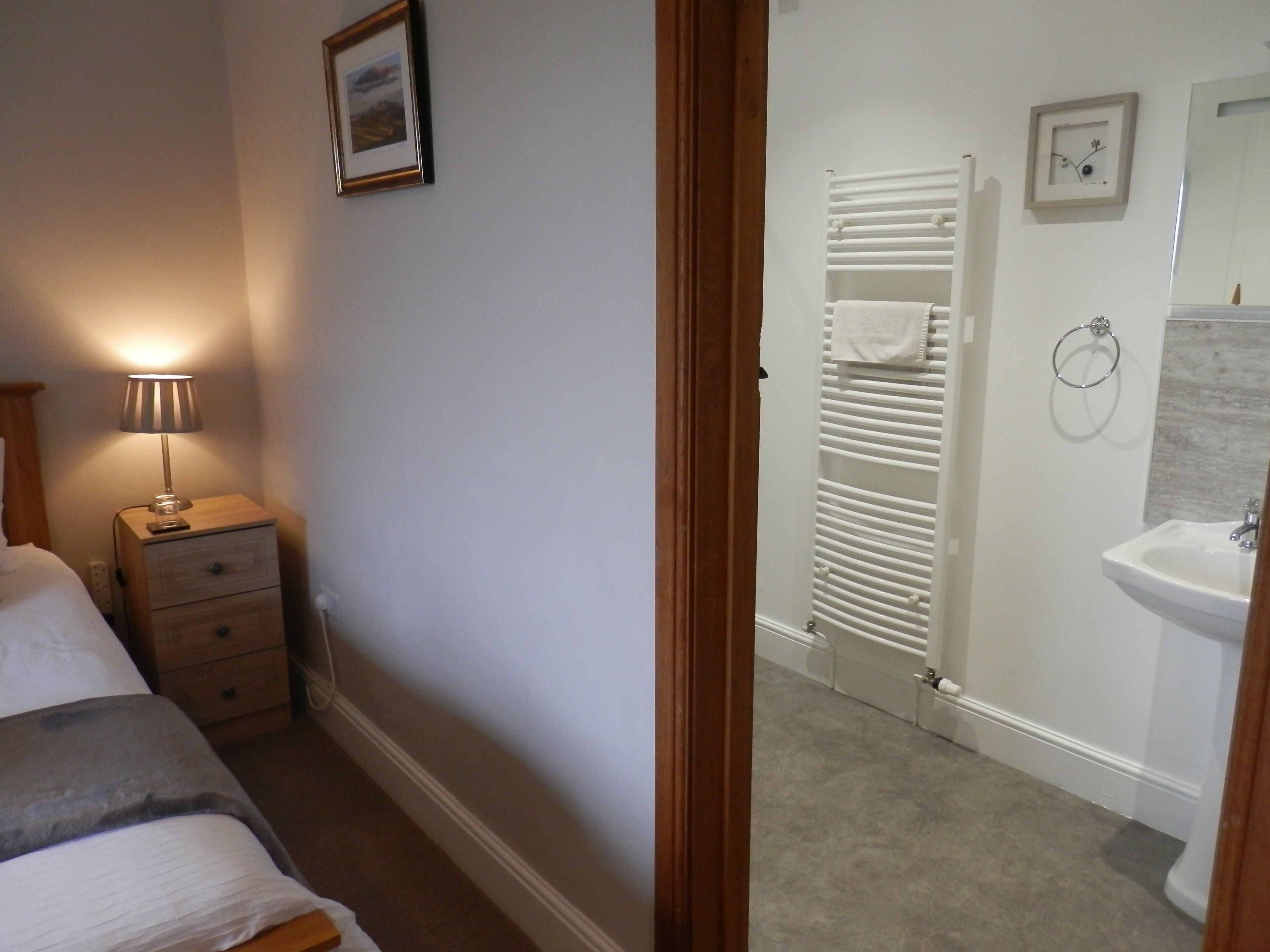 Une chambre à coucher avec un lit, une lampe de chevet et une table de chevet.