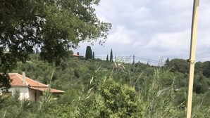 Una mesa y sillas al aire libre con vistas a una colina y un edificio en el fondo.