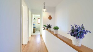 A hallway with wooden flooring, white walls, and a wooden shelf with potted plants. - Villa Rustika with a swimming pool and beautiful Seaview (Sužan (Krk))
