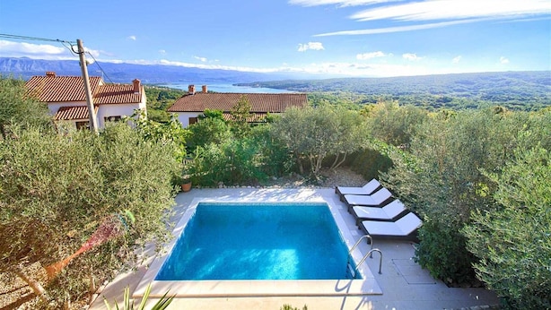 A swimming pool with lounge chairs, surrounded by greenery, with a view of distant mountains and a clear sky. - Villa Rustika with a swimming pool and beautiful Seaview (Sužan (Krk))