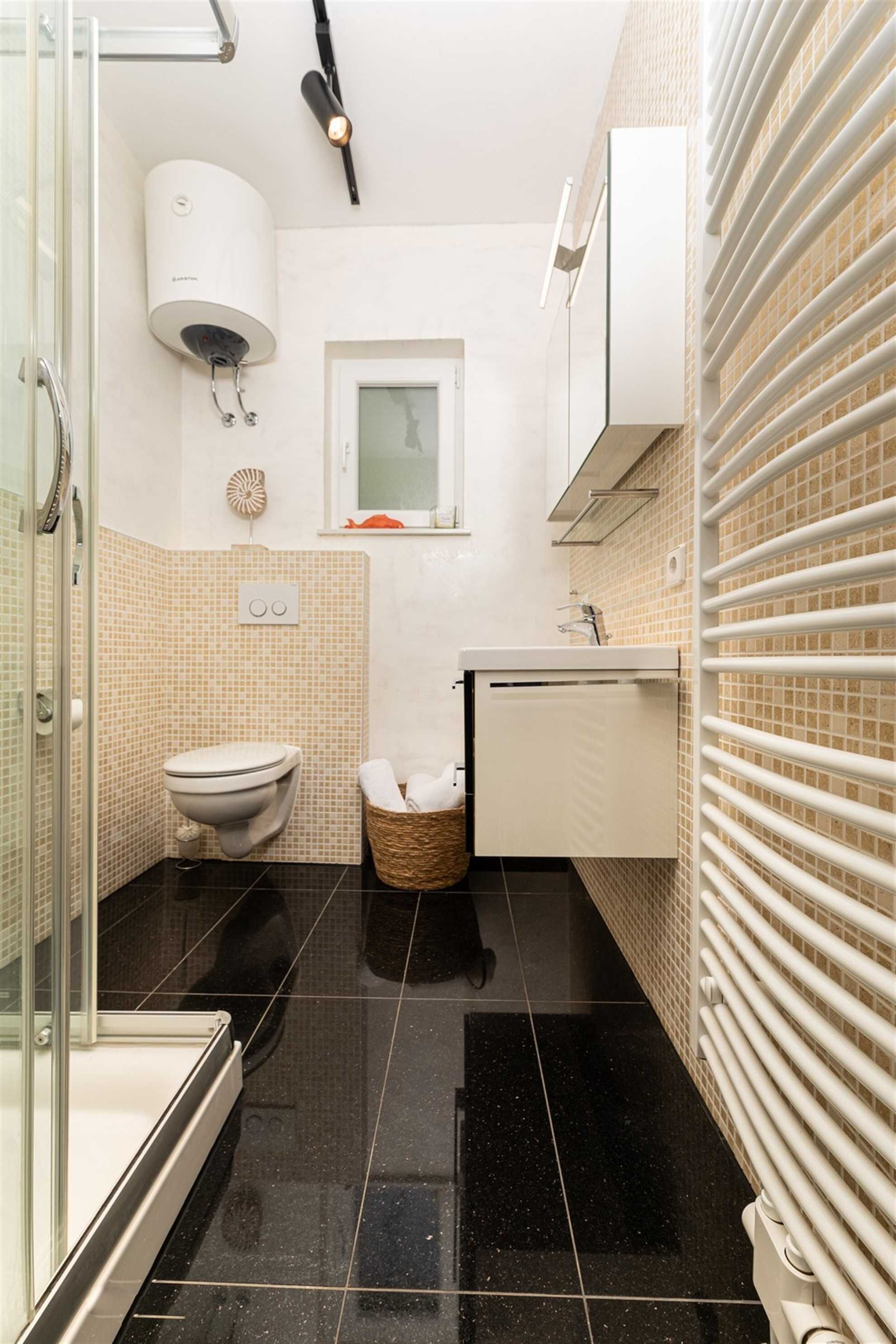 Une petite salle de bain comprenant des toilettes, un lavabo et un porte-serviettes.