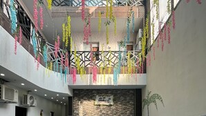 Een binnenzwembad met betegelde wand en muurschildering, omringd door kleurrijke hangdecoraties.