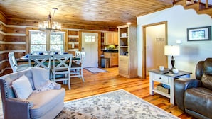 Un intérieur de chalet chaleureux comprenant un coin repas, une cuisine et un espace salon.