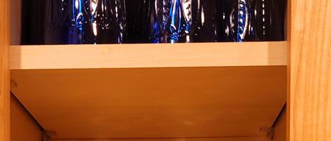 A wooden cabinet with shelves holding various glassware.