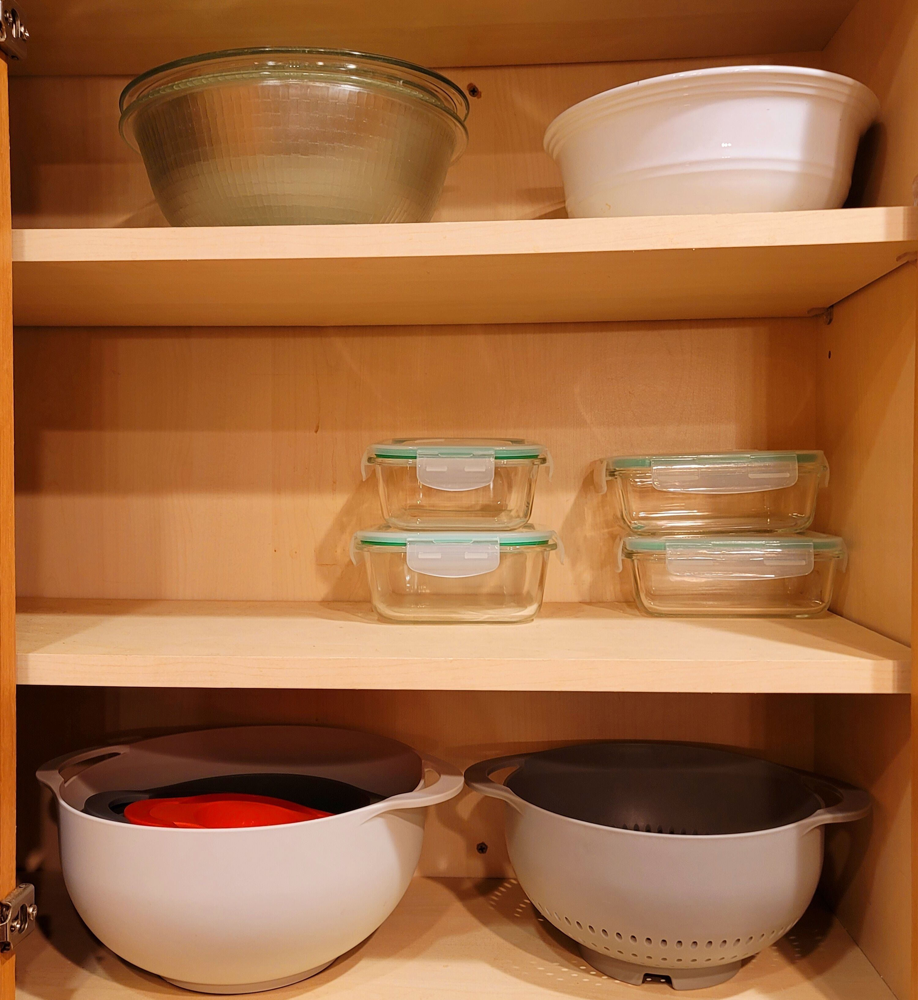 Um armário de cozinha com prateleiras contendo diversos utensílios.