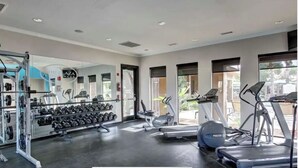 A gym with weightlifting equipment, treadmills, and exercise bikes.