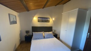 Une chambre à coucher avec un lit, des tables de chevet, une armoire et un tableau au mur.