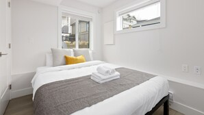 Un dormitorio moderno con una cama grande, una ventana y vistas al exterior.