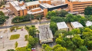 An aerial view of a campus with multiple buildings, parking areas, and green spaces. - Convenient One Bedroom Hancock Condo (Austin)